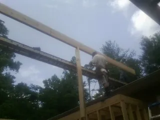 Carpenter setting a ridge beam over a new addition frame — Ice Dam Removal by Roofing Brothers in Crestline