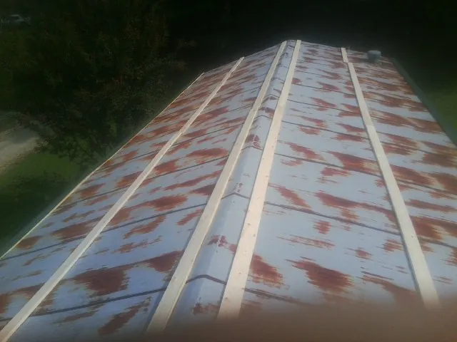 Rusted metal roof panels with new wood purlins before replacement — Storm Damage Roof Repair in Crestline by Roofing Brothers
