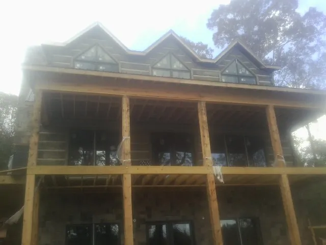 Dormers and porch framing on a large log home under construction — Roof Coating work by our crew in Crestline